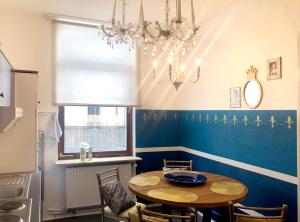 a dining room with a table and a chandelier at Königssuite in Bremen