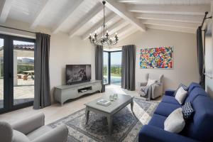 a living room with a blue couch and a tv at Villa Edoardo by Villas Holiday in Vižinada
