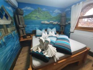 1 dormitorio con 1 cama con una pintura en la pared en Resort Svět, en Úžice