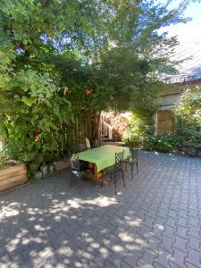 un patio con mesa, sillas y un árbol en Apartmán Na statku en Miskovice