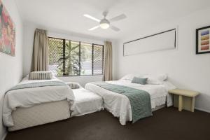 a bedroom with two beds and a window at Lakeshores 41 Coongarra in Kawana Waters