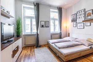 um quarto com uma cama e uma televisão de ecrã plano em COZY + TRENDY by JR City Apartments em Viena