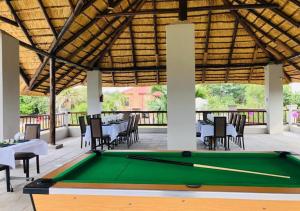 a pool table in a pavilion with tables and chairs at ASANTE MOUNTAIN LODGE in Hazyview