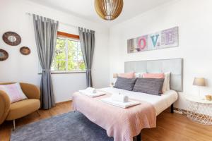 ein Schlafzimmer mit einem Bett, einem Stuhl und einem Fenster in der Unterkunft Privilege Apartment Magnolia, Olhão in Olhão