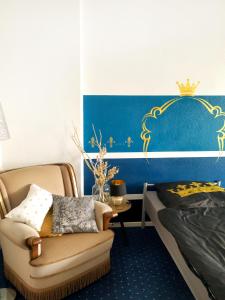 a bedroom with a bed and a chair and a bed and a bed at Königssuite in Bremen