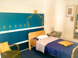 a small bedroom with a bed and a chair at Königssuite in Bremen +2 photos