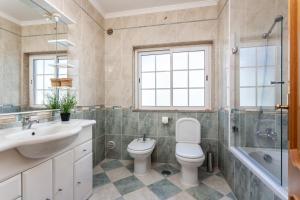 a bathroom with a toilet and a sink and a tub at Privilege Apartment Magnolia, Olhão in Olhão +13 photos