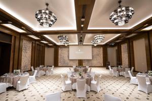 a banquet hall with white tables and white chairs at InterContinental Fujairah Resort by IHG in Al Aqah +161 photos