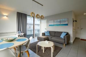 ein Wohnzimmer mit Couch und Tisch in der Unterkunft Zeesymfonie Oostduinkerke in Koksijde