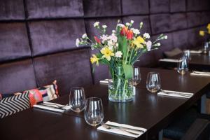 un jarrón de flores sobre una mesa en un restaurante en Scandic Gdańsk, en Gdansk