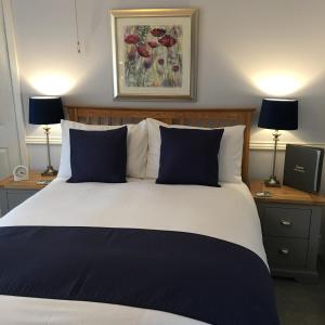 a bedroom with a large bed with blue pillows at Spurwing Guest House in Wareham
