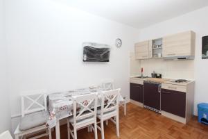 una pequeña cocina con mesa y sillas en una habitación en Apartment Gabriel, en Rovinj