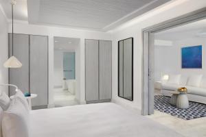 Mykonos Riviera Hotel & Spa, a member of Small Luxury Hotels of the World tesisinde bir odada yatak veya yataklar