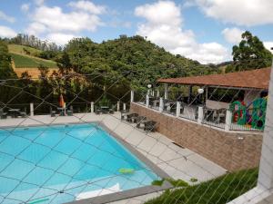 an image of a swimming pool with a mountain in the background at Rancho das Montanhas in Muniz Freire