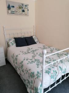 a bedroom with a white bed with a floral bedspread at Chatham Private Rooms in Chatham