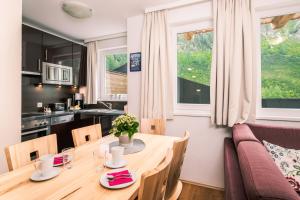 eine Küche und ein Esszimmer mit einem Holztisch und Stühlen in der Unterkunft Obertauern Alps 4-Zimmer Appartement - Top 6 in Obertauern