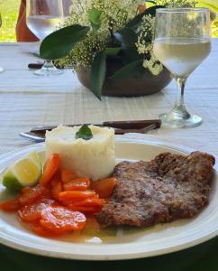 un plato de comida con carne y verduras y una copa de vino en Estancia Buena Vista en Esquina