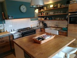 a kitchen with a wooden counter top with a basket on it at Le Maine Menot in Salles-Lavalette