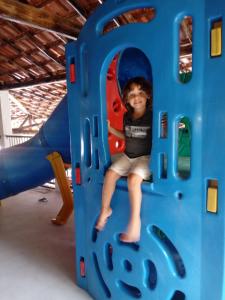 Un jeune garçon est assis dans une structure de jeu dans l'établissement Rancho das Montanhas, à Muniz Freire
