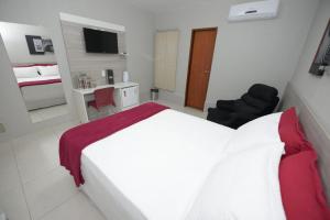 a hotel room with a white bed and a desk at Hotel Leon in Barbalha +18 photos