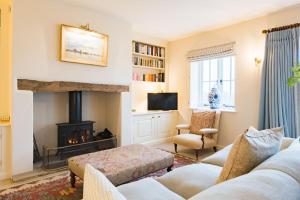 a living room with a fireplace and a tv at Bushes Oast by Bloom Stays in Sevenoaks