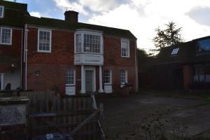 uma casa de tijolos com uma cerca em frente em Whitefriars em Rye