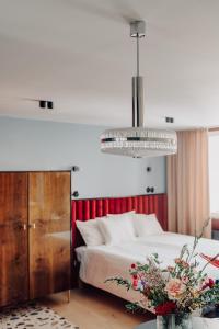 - une chambre avec un lit et un lustre dans l'établissement Apartament przy MCK, à Katowice