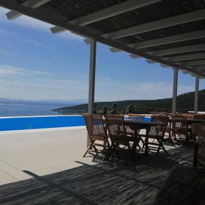 einen Tisch und Stühle auf einer Terrasse mit Meerblick in der Unterkunft Celini Suites Hotel in Marmarion