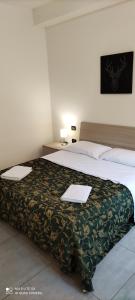 ein Hotelzimmer mit einem Bett mit zwei Papieren darauf in der Unterkunft Sweet Napoli in Neapel