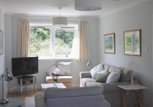 uma sala de estar com um sofá e uma televisão em Apartment Sula Bassana em North Berwick