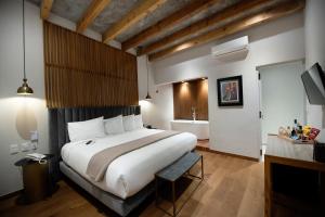 a bedroom with a large bed and a bathroom at Hotel Madi in San Miguel de Allende