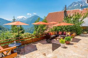 a patio with tables and chairs and umbrellas at Chalet La Maitreya in Vaujany