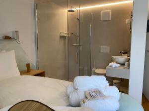 ein Schlafzimmer mit Dusche und ein Bett mit Handtüchern in der Unterkunft Espace Entre Ciel & Terre in Montavon