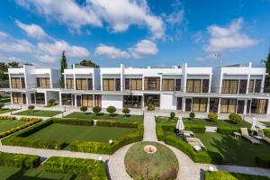an exterior view of a building with a garden at Cosmopolis Multi-Venue in Larnaca