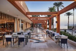 ルクソールにあるSteigenberger Resort Achtiの海とテーブルと椅子が備わるレストラン