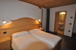 Ένα ή περισσότερα κρεβάτια σε δωμάτιο στο Albergo Alpino