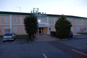 a building with a car parked in front of it at Fasthotel Bordeaux Eysines in Eysines