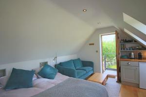 a bedroom with a bed and a blue couch at Pudswell Studio in Burford