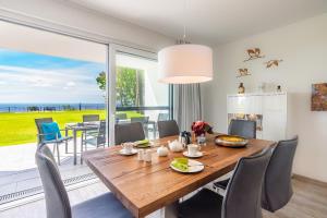 GarzにあるTerrassenwohnung "Kranich" - Oase am Haffの木製のテーブルと椅子のあるダイニングルーム
