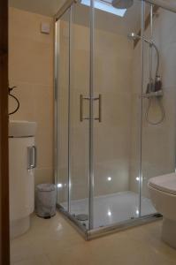a shower with a glass door in a bathroom at Cedar Lodge 2 ensuite bedroom cottage near Bath in Box