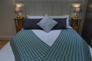 a bedroom with a large bed with blue pillows at Cedar Lodge 2 ensuite bedroom cottage near Bath in Box
