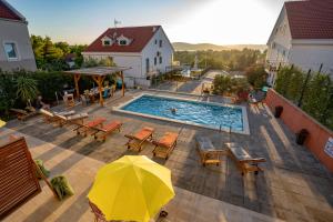 een uitzicht over een zwembad met een gele parasol bij Villa Dada i Dida in Milna