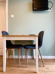 a desk with two chairs and a television on a wall at Solunska Stylish Apartment in Sofia