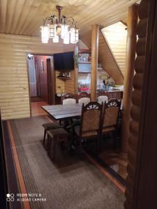 a dining room with a wooden table and chairs at Sadyba Gostynniy Dvir in Izki