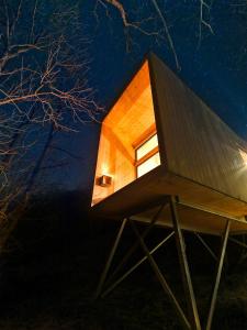 a small house on a stand at night at Treehut, nature, birds, silence and fjord in Samlanes