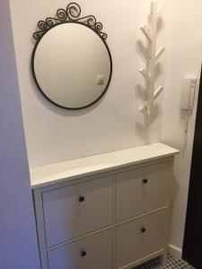 a mirror on a wall above a dresser in a bathroom at Solunska Stylish Apartment in Sofia