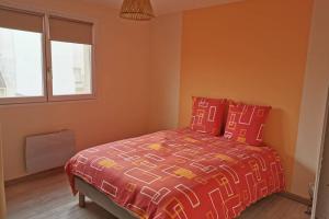- une chambre avec un lit doté d'oreillers rouges et une fenêtre dans l'établissement Gite de la Digue, à Wissant