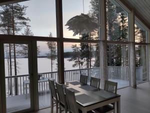 un porche cubierto con mesa y sillas en Villa Sirius Sieri, nice Log-Cottage by the lake, en Rovaniemi