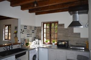 una cucina con armadi bianchi e piano cottura di Les mansardes Le gîte a Sarlat-la-Canéda