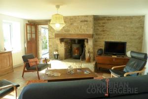 a living room with a couch and a fireplace at Belle longère en campagne à Larmor Baden in Larmor-Baden